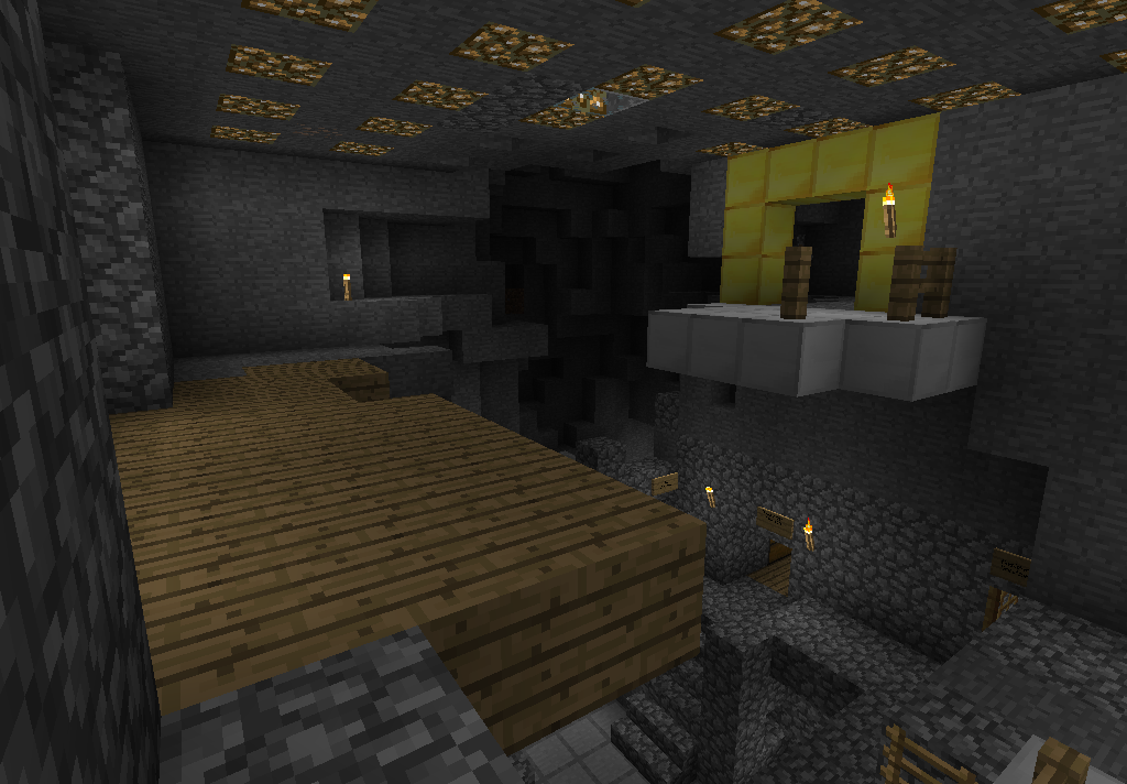 A large underground base with a fireplace and wooden floor.