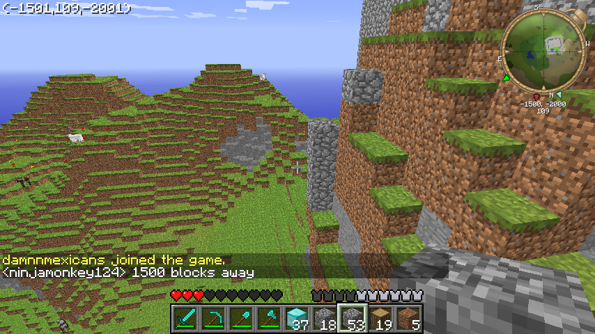 A mountainous terrain with a large cliff face and a body of water in the distance. The player's inventory is visible at the bottom of the screen.