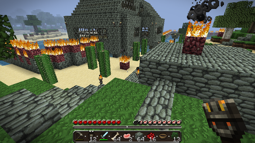 A large stone building with a fire on top, surrounded by green blocks and trees.