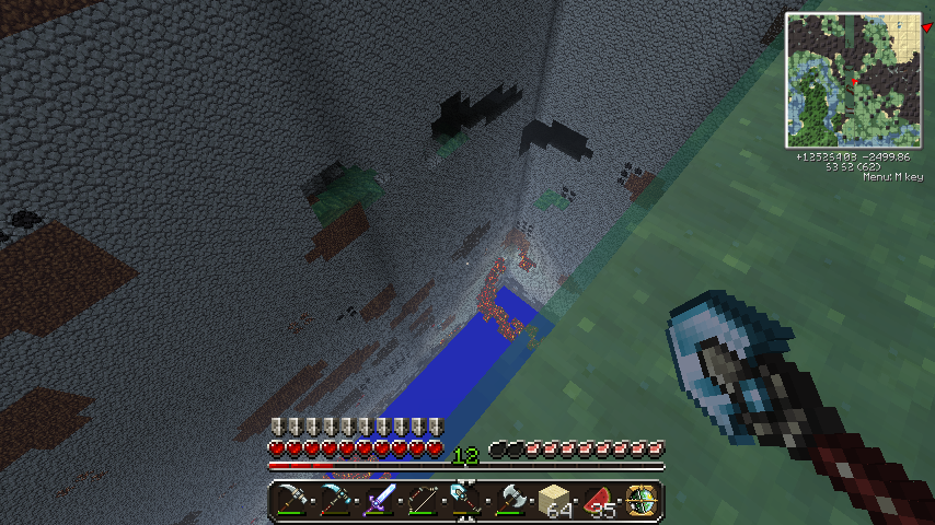 A player is mining in a cave, with a pickaxe in hand and a block of dirt being mined.