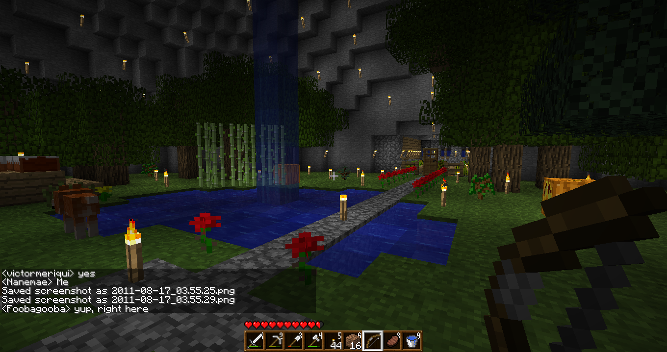 A build of a blue pool with red flowers and a path leading to it, surrounded by trees and other natural features.