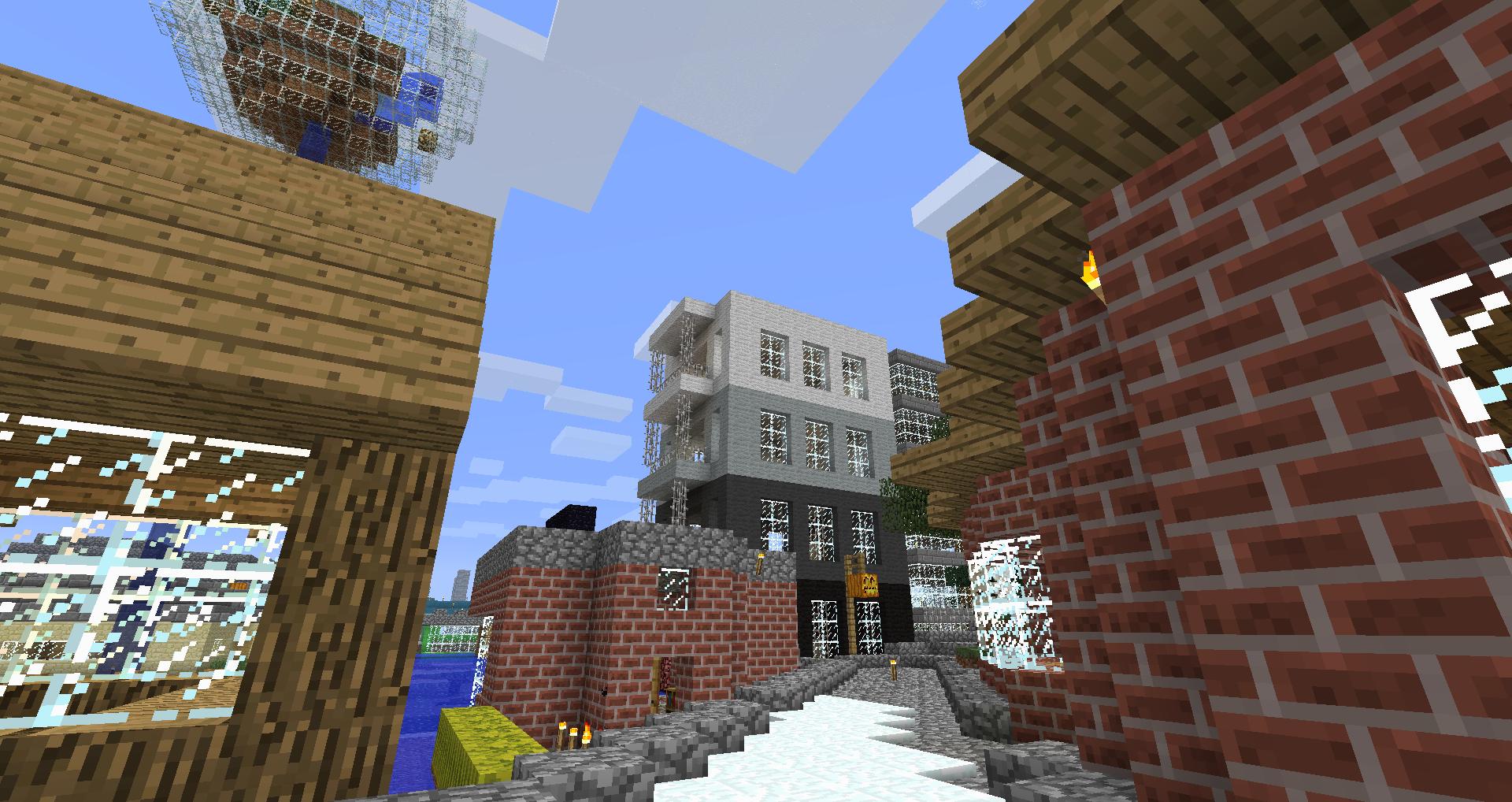 A large city with many buildings and structures, including a red brick building and a white building with a black base.