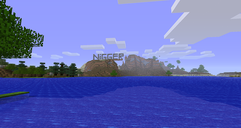 A large body of water with a mountain range in the background, featuring the word 'NIGGER' written on it.
