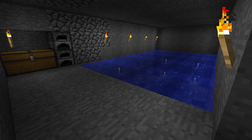 A large underground room with a blue pool of water in the center, surrounded by stone walls and lit by torches.