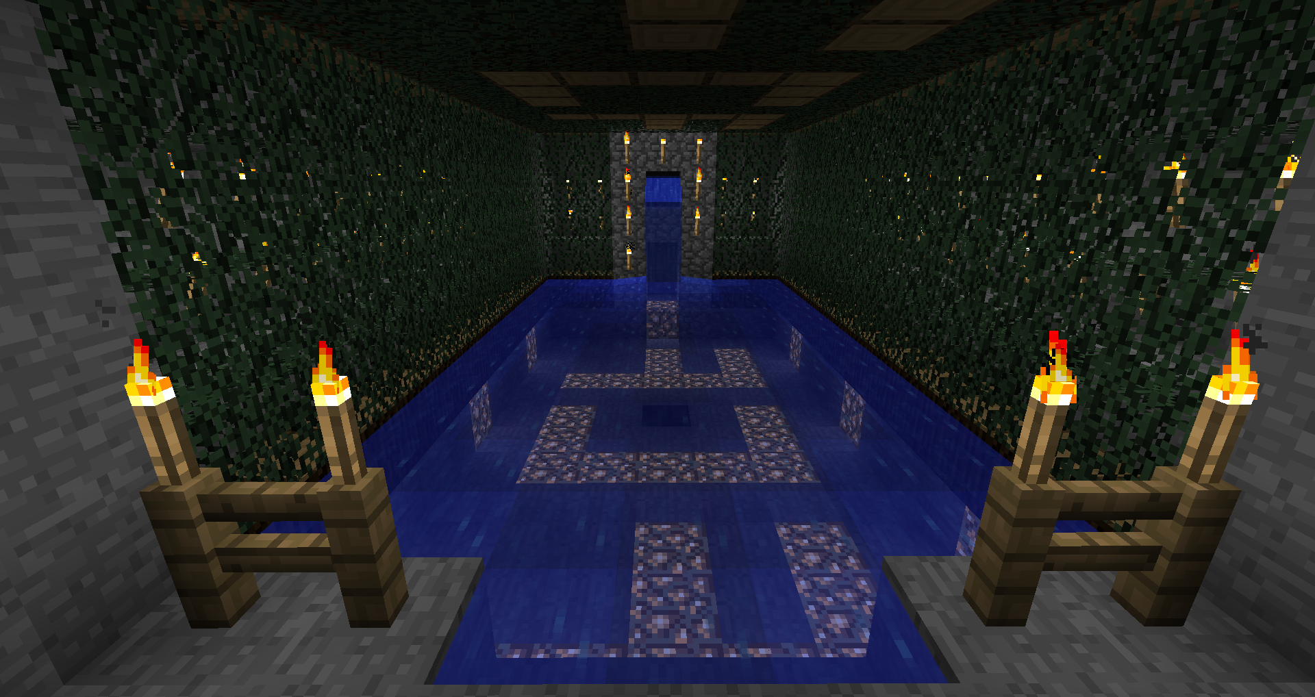 A large blue room with a swastika in the center, surrounded by candles and greenery.