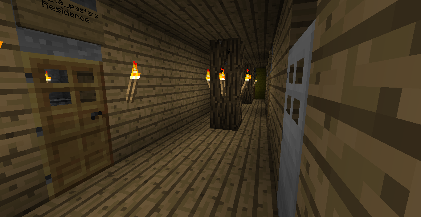 A long hallway with a door at the end and lit torches on the walls.
