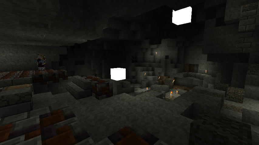 A dark cave with a few lit torches and a small pool of water.
