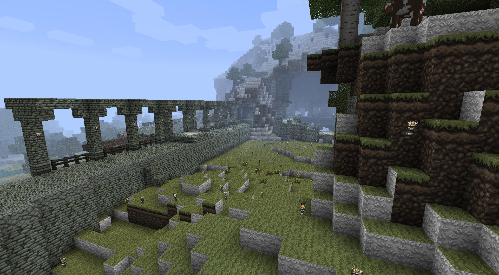 A large, abandoned base with a grassy courtyard and stone walls, featuring a mix of natural terrain and constructed elements.