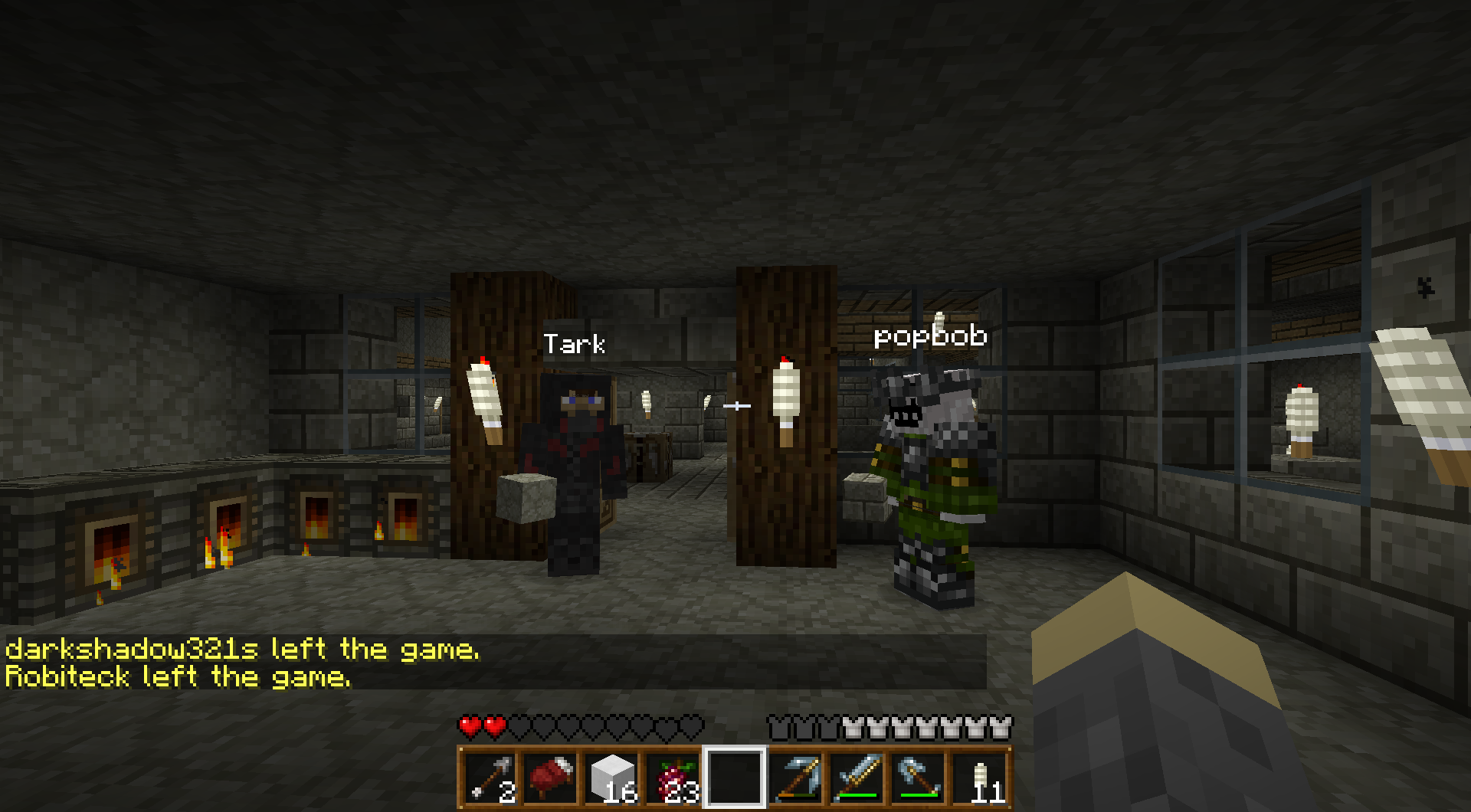 A dark room with several players and a few signs, with chat messages visible.