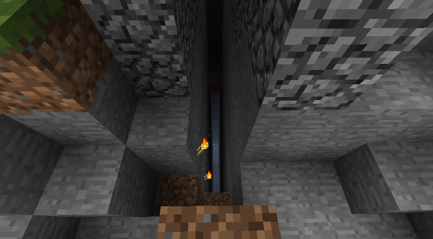 A deep hole with lava at the bottom, surrounded by stone blocks and a few torches.