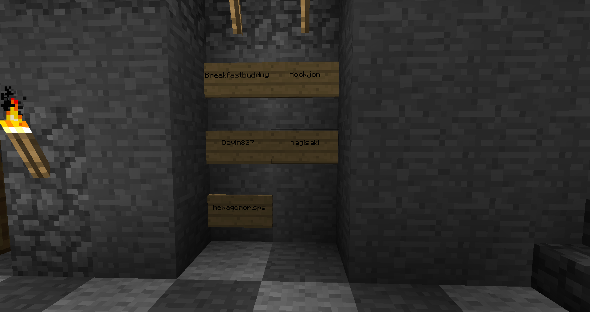 A dark room with a series of signs on the wall, featuring text in an unknown language.