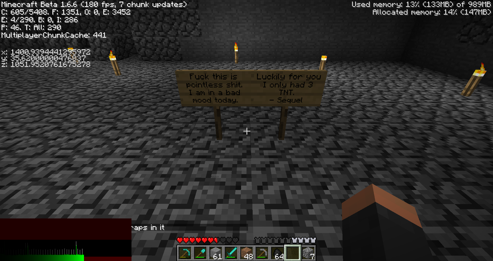 A sign with a message in a dark cave, with a player's inventory visible at the bottom.