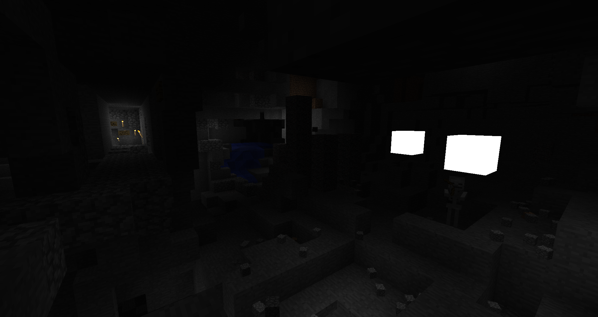 A dark room with a few lit blocks, possibly a base or build.