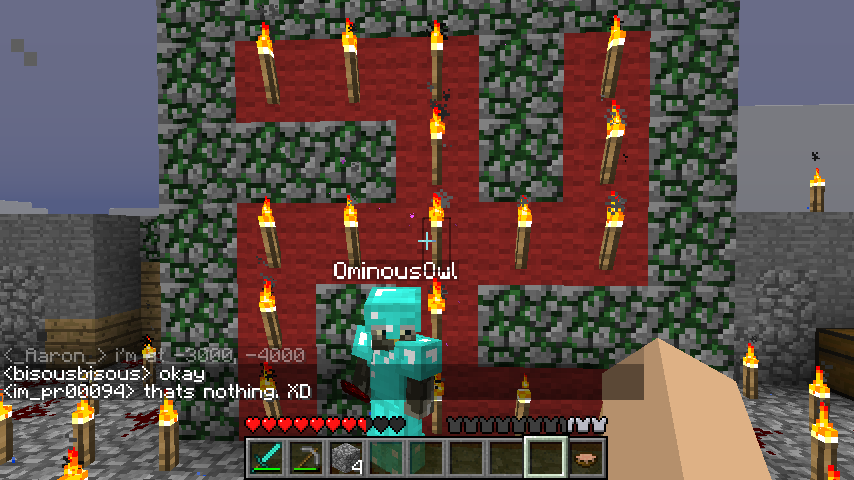A large swastika made of redstone torches and stone bricks, with a player standing in front of it.