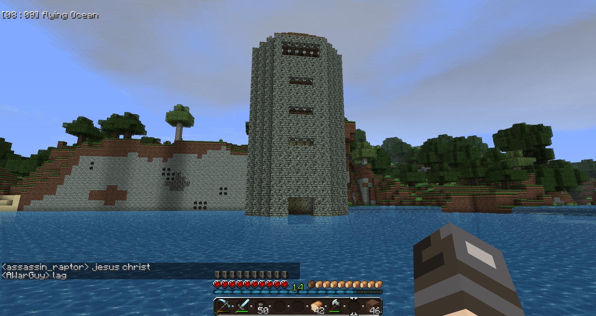 A large stone tower in the middle of a body of water, with a small island behind it.