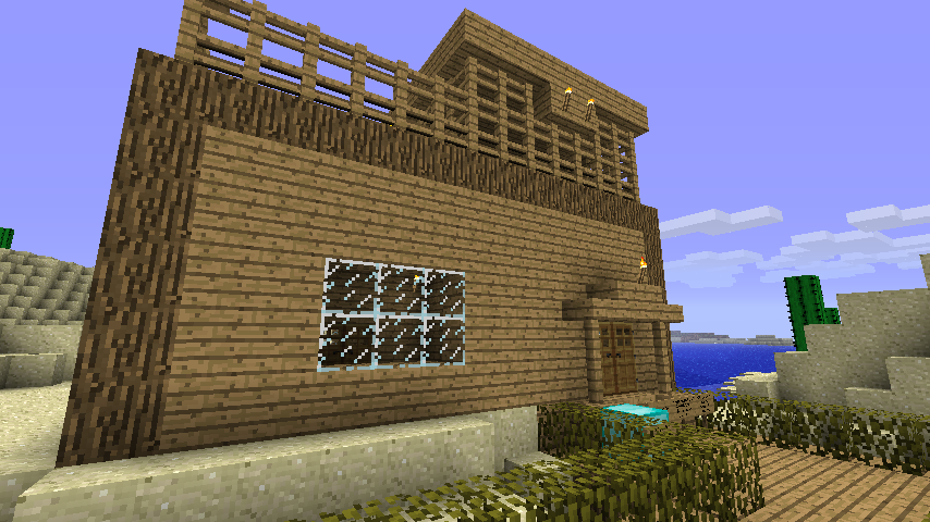 A large wooden house with a balcony and a view of the ocean.