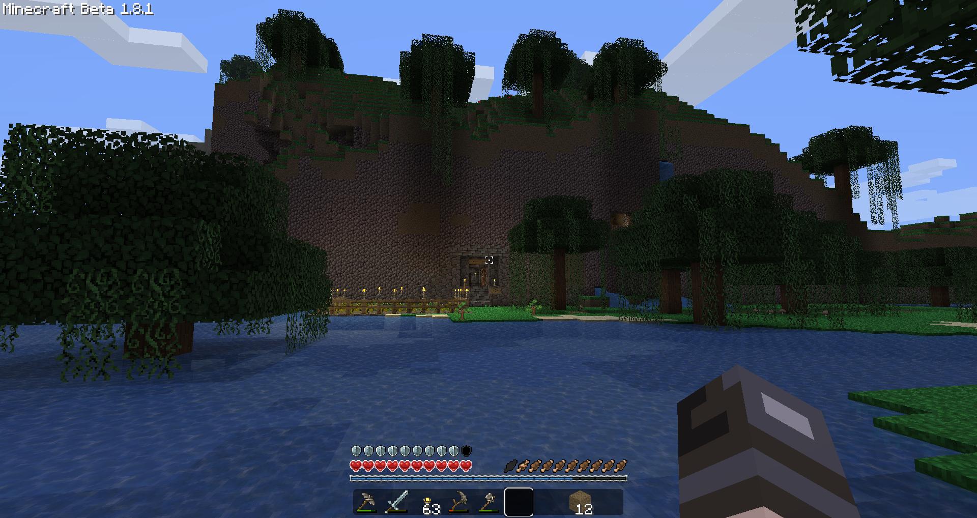 A player is standing in front of a large body of water, with a small island in the distance. The player's inventory is open, showing various items.