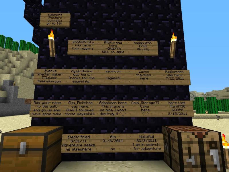 A large black monument with many wooden signs on it, in a desert biome.
