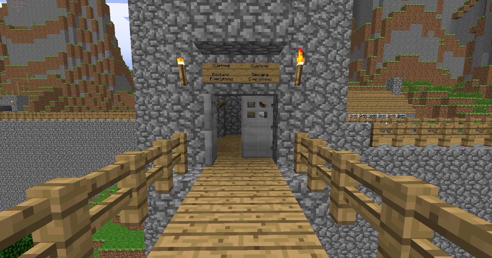 A stone building with a wooden bridge leading to it, featuring a sign above the entrance.