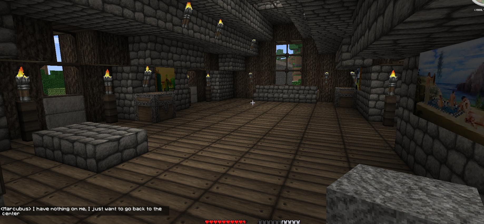 A large room with stone walls and a wooden floor, featuring several torches and a window on the right side.