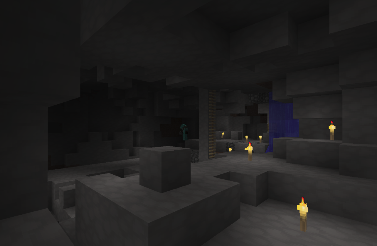 A dark cave with a few lit torches and a blue portal.