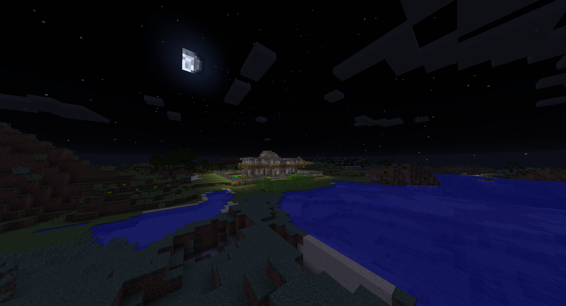 A nighttime scene of a large body of water with a building in the distance.