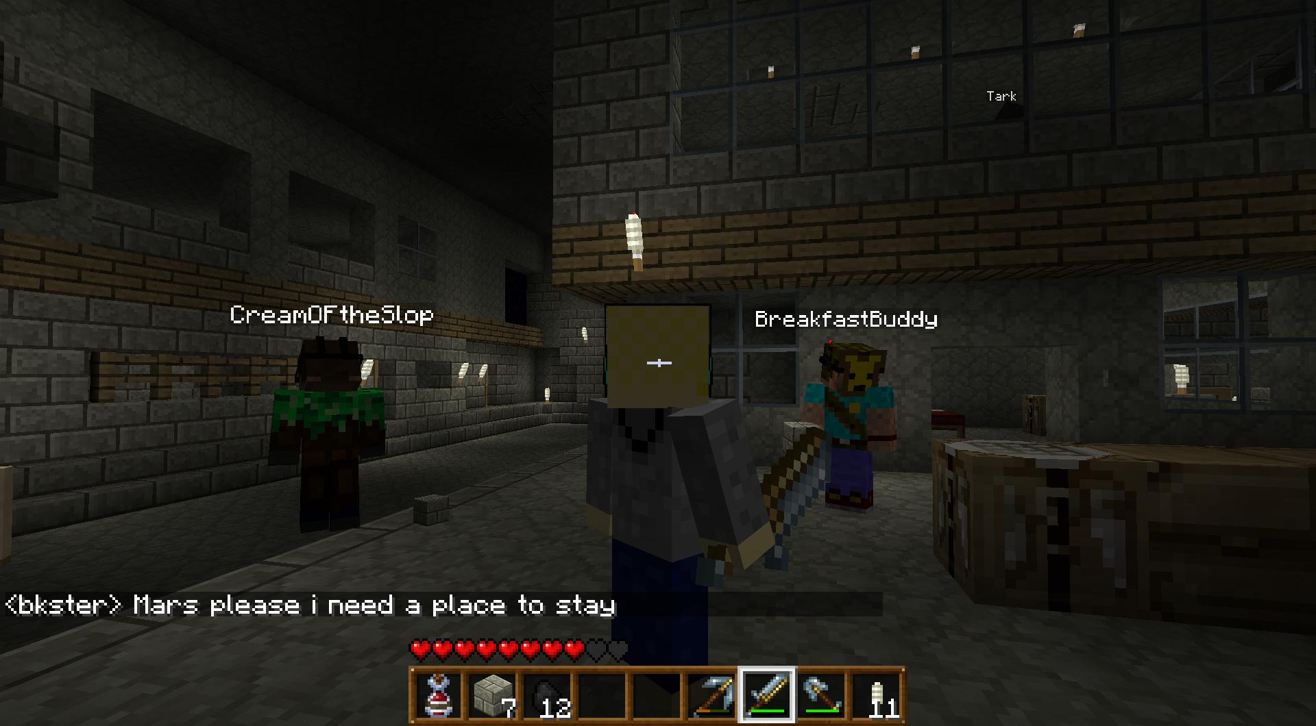 A player is standing in a dimly lit room with other players, with chat messages visible.