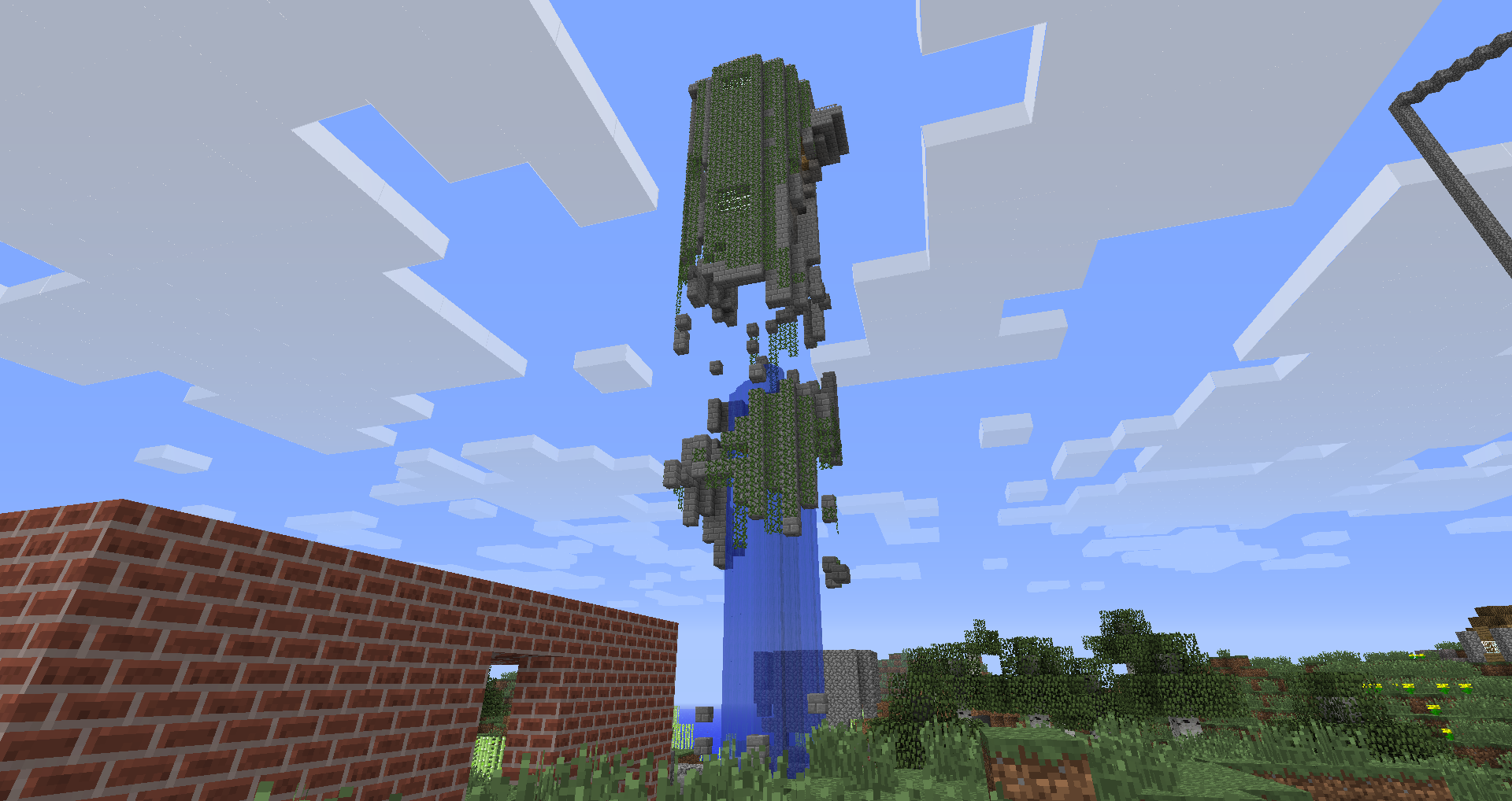A tall blue pillar with green blocks on top, surrounded by a brick wall and trees.