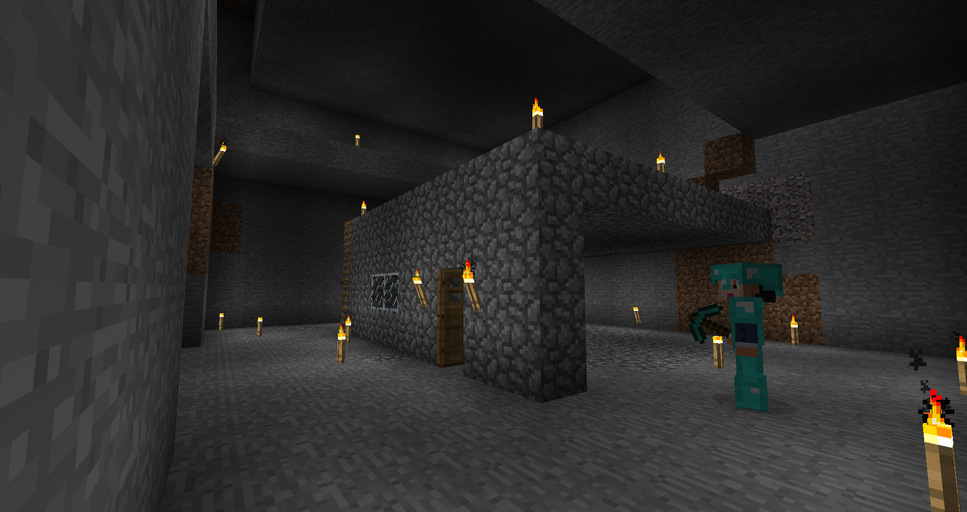 A dark room with a stone wall and a few pillars, lit by torches.