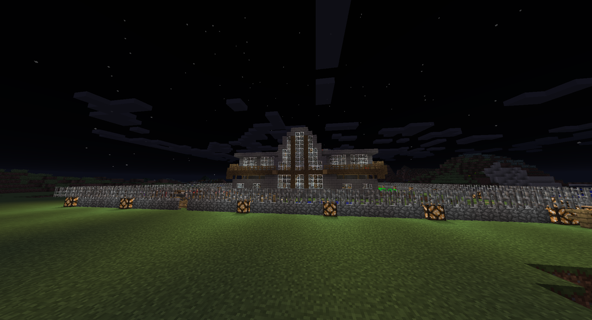 A large base with a wall and a building in the center, surrounded by a grassy field.