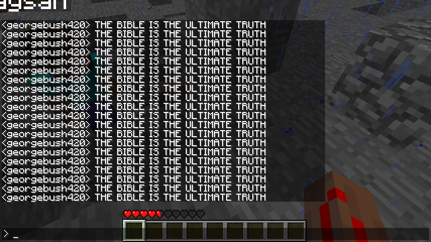 A large, black, rectangular sign with white text that reads 'THE BIBLE IS THE ULTIMATE TRUTH' repeated multiple times.