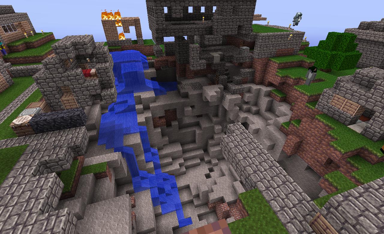 A large ravine with a waterfall, surrounded by buildings and structures.