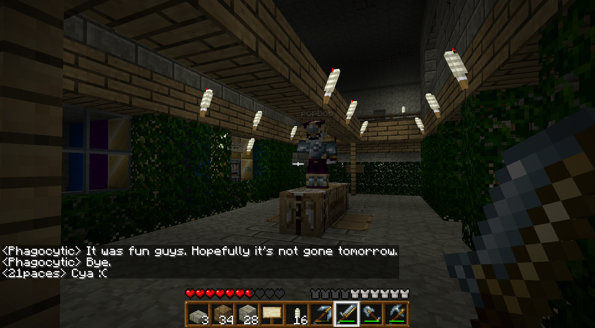 A player is standing in a dimly lit hallway with a sign on the wall and a chat message displayed.