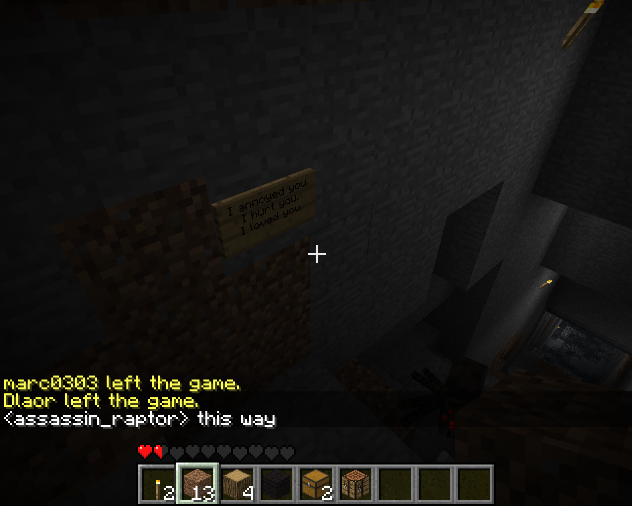A dark room with a sign on the wall and chat messages at the bottom of the screen.