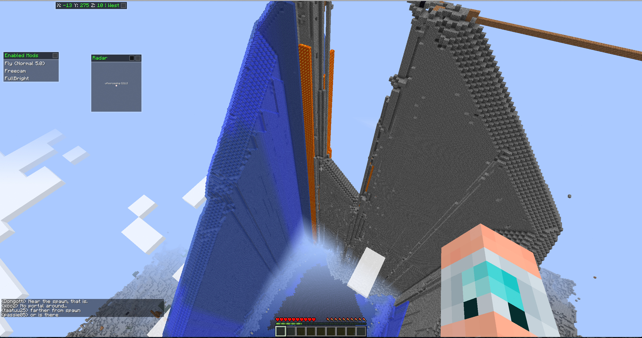 A large, intricate build with a blue and orange color scheme, featuring a tall structure with a pointed top and a smaller, cube-shaped building nearby.
