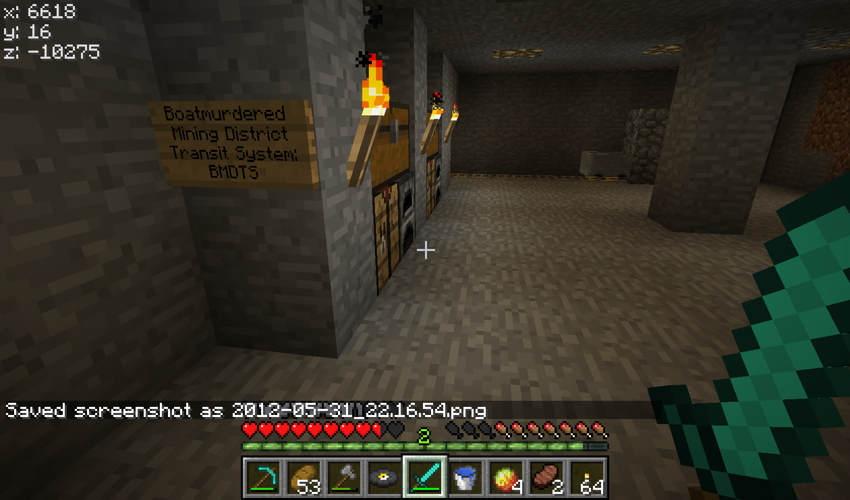 A dimly lit underground base with a sign that reads 'Boatmurdered Mining District Transit System: BMDTS' and a player's inventory at the bottom of the screen.