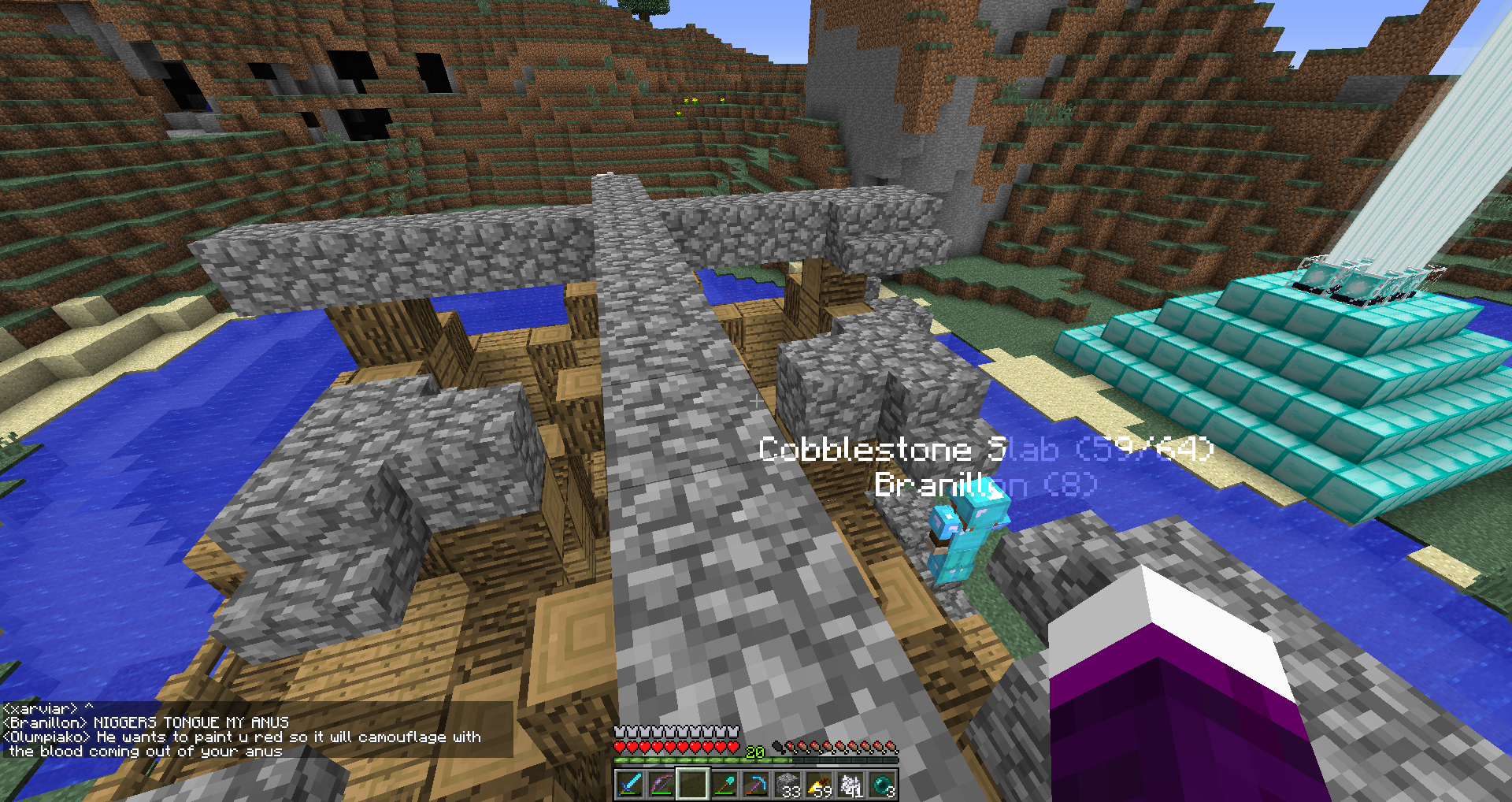 A large stone structure with a blue pool of water in the middle, surrounded by a desert biome.