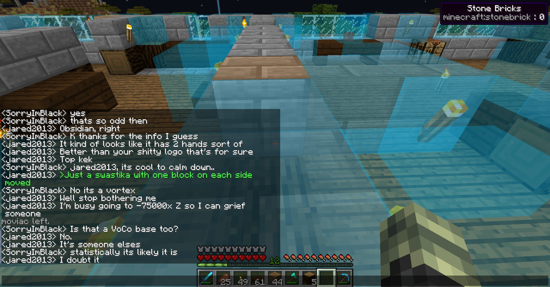 A player is building a base in the water, with a large stone structure and a smaller wooden one nearby. The player is using a variety of blocks, including stone, wood, and glass, to create a unique and intricate design.