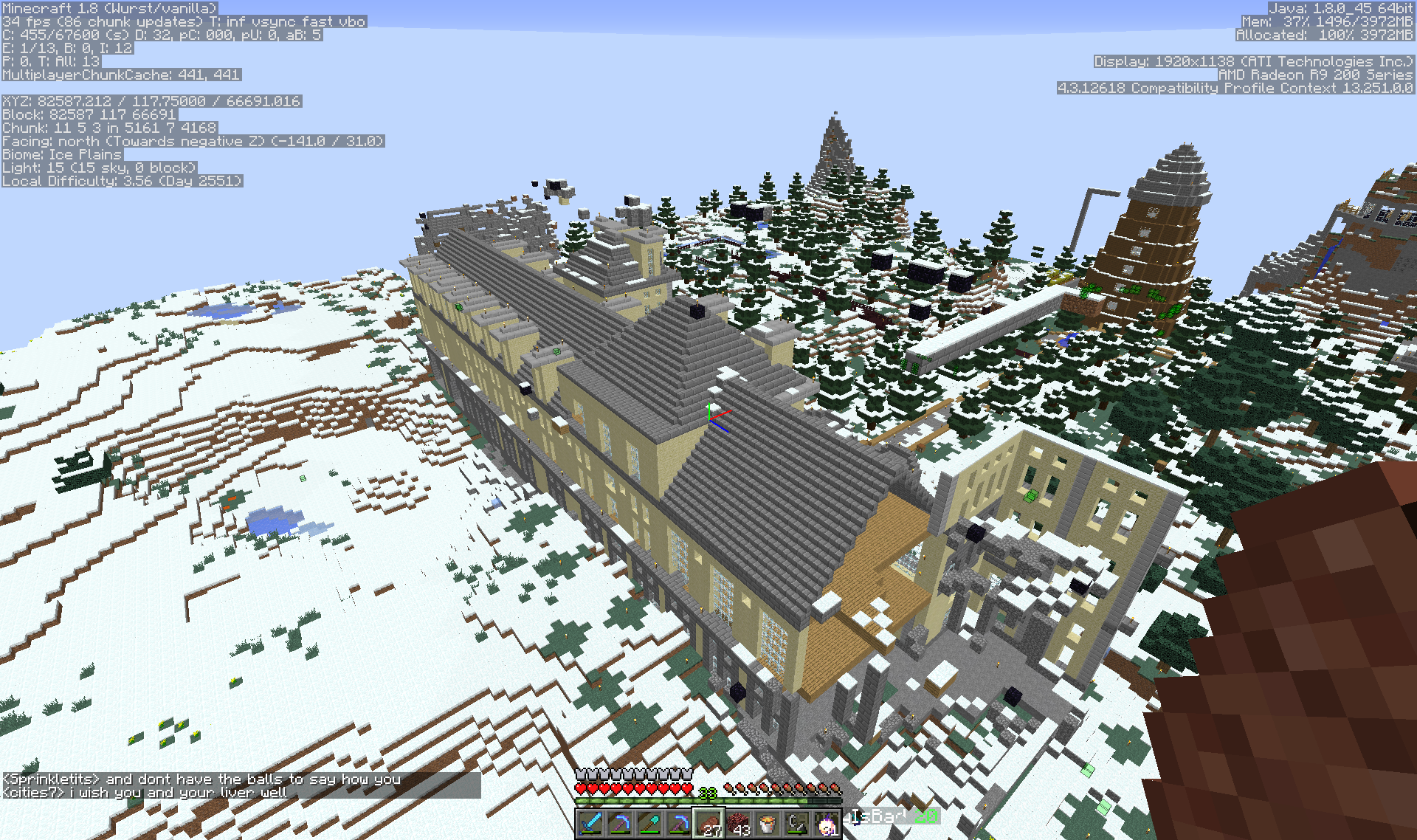A large building in a snowy biome with trees and mountains in the background.